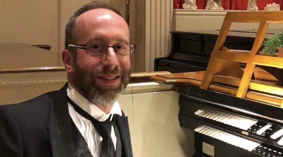 Photo of organist David Hufford in front of an organ